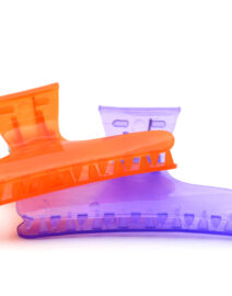two hair claw clips of different colors, one orange and one violet, on a white background